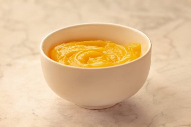 Ev yapımı taze puding ya da beyaz bir kasede mermer arka planda keskin limon püresi..