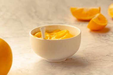 Lezzetli sarı limonlar ve limonlu kompozisyon mermer arka planda beyaz sosis kasesi..