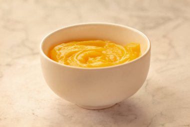 Ev yapımı taze puding ya da beyaz bir kasede mermer arka planda keskin limon püresi..