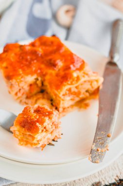 Yanında beyaz bir tabakta peynirli lazanya dilimlenmiş leziz sığır eti. Lokanta menüsü, yemek tarifi..