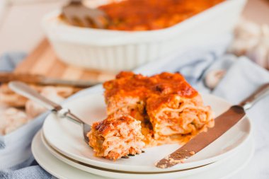Yanında beyaz bir tabakta peynirli lazanya dilimlenmiş leziz sığır eti. Lokanta menüsü, yemek tarifi..