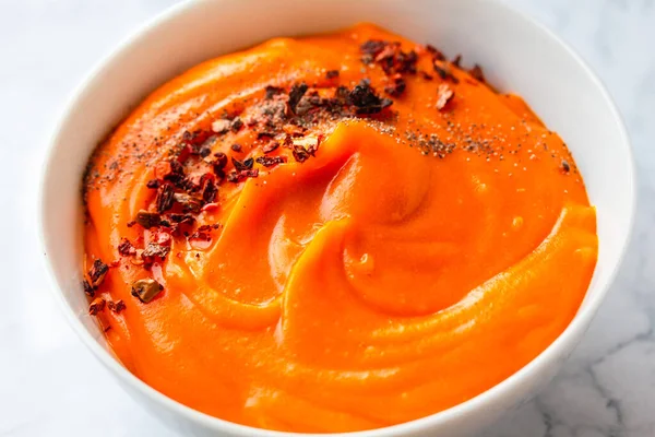 チリフレークペッパーとクリーミーなおいしいカボチャのスープのボウル 秋の快適食のコンセプト — ストック写真