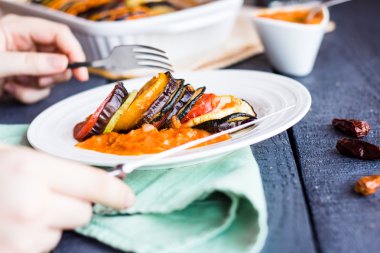 soslu bir tabakta sebze ratatouille yeme