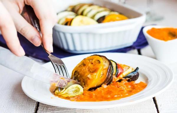 Mangi ratatouille vegetale con una forchetta e un coltello, mani — Foto Stock