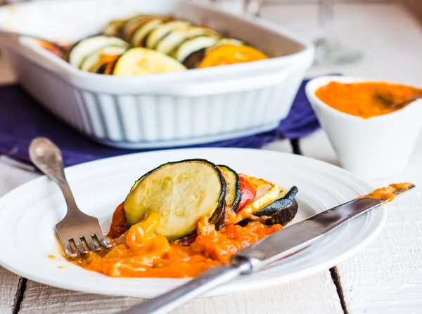 Succosa ratatouille servita in un piatto rotondo con salsa, forchetta, knif — Foto Stock