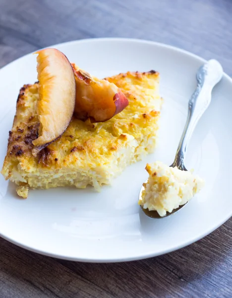 Caçarola de queijo cottage doce com massas e pêssegos, um teaspoo — Fotografia de Stock