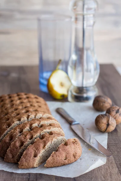 Roggenbrot in Scheiben geschnitten mit einem Messer, Walnüsse, Birne, senkrecht — Stockfoto