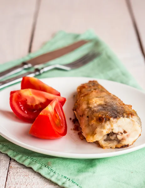 Gegrillter Fisch mit Tomate auf Teller, Gabel und Messer — Stockfoto