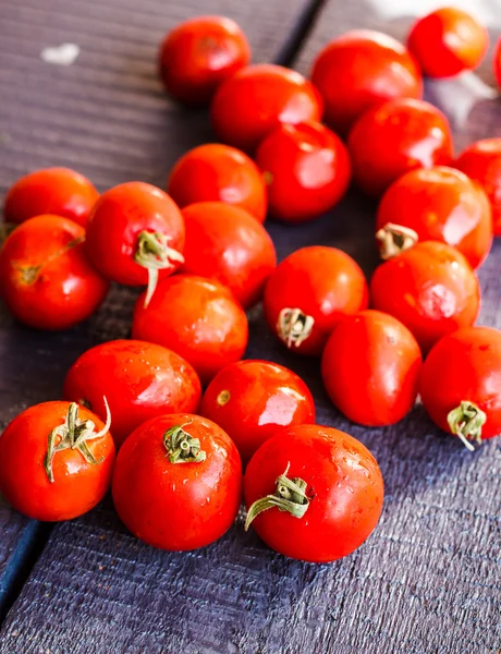 Red  tomatoes cherry on dark wooden board,  vertically — Stock Photo, Image