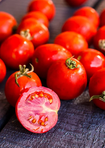 Red juicy tomatoes cherry on dark wooden board — Stock Photo, Image