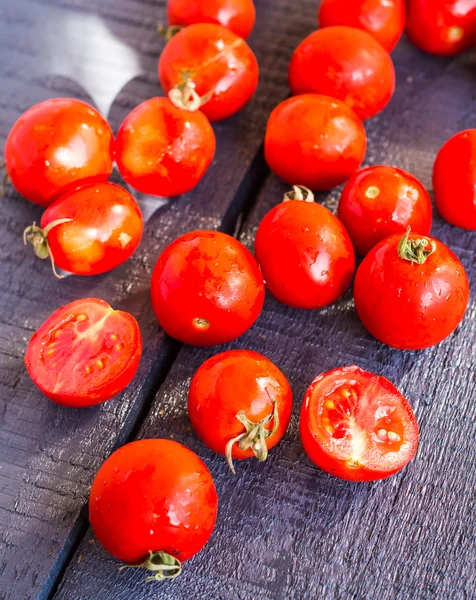 Red juicy tomatoes cherry on dark wooden board — Stock Photo, Image