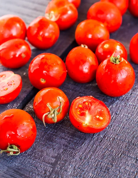 Tomatoes cherry on dark wooden board, closeup — Stock Photo, Image