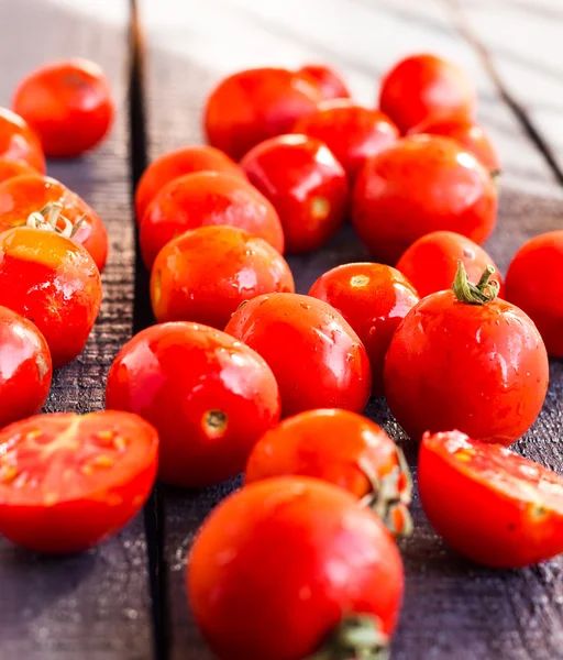 Red juicy tomatoes cherry on dark wooden board — Stock Photo, Image