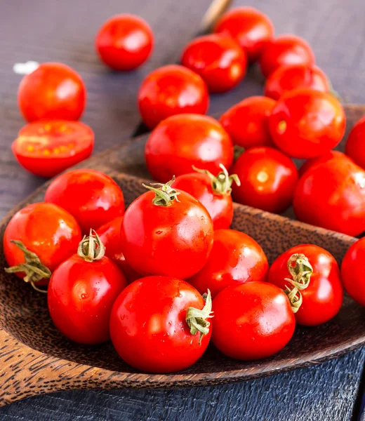 Tomatoes cherry in brown wooden plate, vertically — Stock Photo, Image