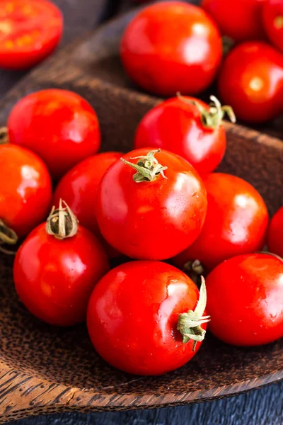 Red juicy tomatoes cherry in brown wooden plate — Stock Photo, Image