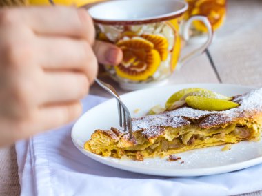 işlem Apple strudel eller, beyaz bir tabakta yemek 