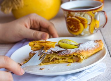 Beyaz bir plaka üzerinde eller elma meyveli turta yemek