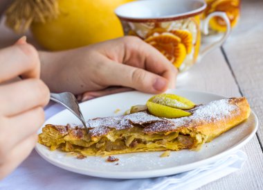 işlem Apple strudel eller, beyaz bir tabakta yemek 