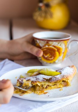 Beyaz bir plaka üzerinde eller elma meyveli turta yemek,