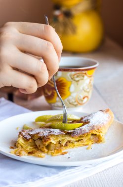 Beyaz bir plaka üzerinde eller elma meyveli turta yemek,