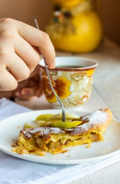 Beyaz bir plaka üzerinde eller elma meyveli turta yemek,