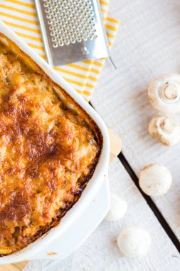 bir kara tahta üzerinde beyaz bir kase mantar eti lazanya 