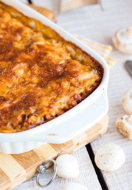 bir kara tahta üzerinde beyaz bir kase mantar eti lazanya 