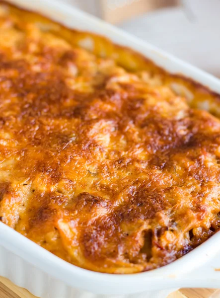 Meat lasagna with mushrooms in a white bowl on a blackboard — Stock Photo, Image