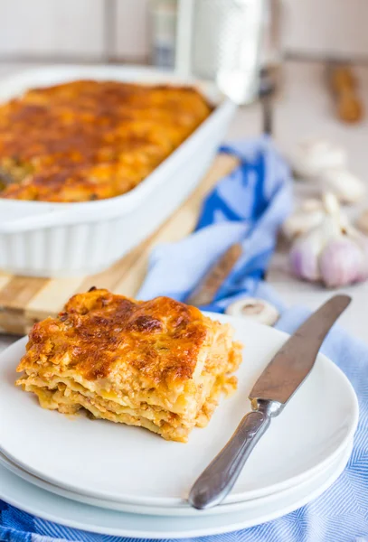 Fleischlasagne mit Pilzen auf weißem Teller — Stockfoto