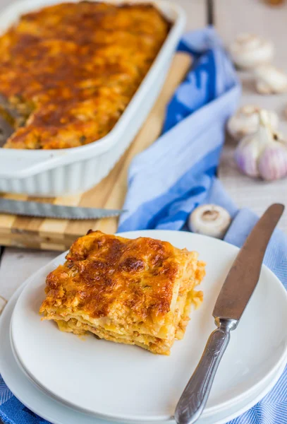 Trozo de lasaña de carne con setas en un plato blanco —  Fotos de Stock