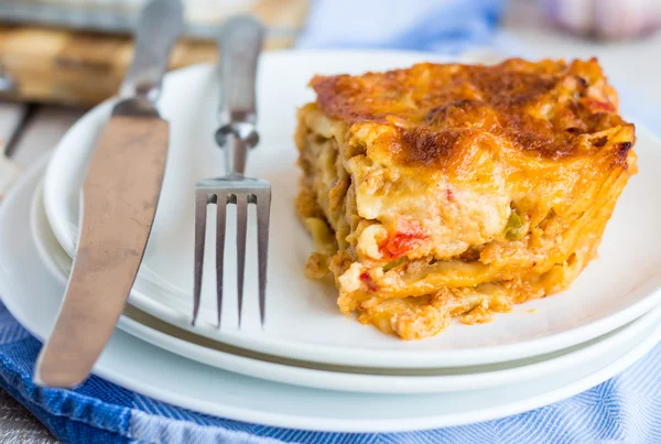 Kus masa lasagne s houbami na talíři, příbory — Stock fotografie