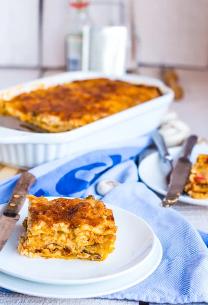 Manger un morceau de lasagne à la viande aux champignons, serviette bleue — Photo