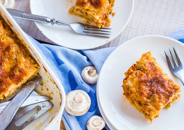 Kus masa lasagne s houbami, příbory, — Stock fotografie