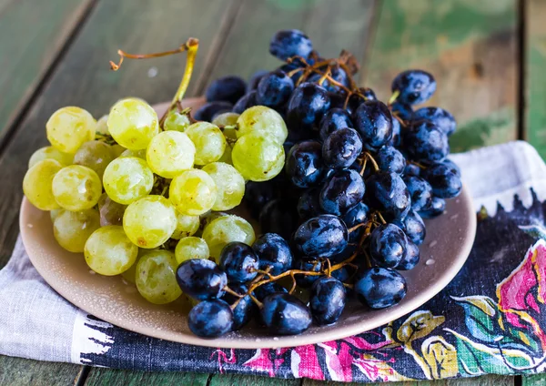 Aglomerado doce de uvas verdes e azuis em um prato — Fotografia de Stock