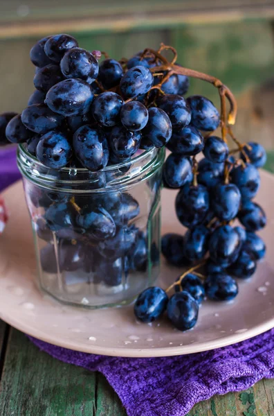 皿の上のガラスの青ブドウの小枝支店 — ストック写真