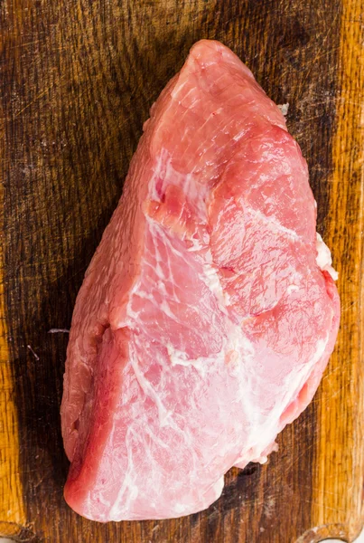 Piece of pork on a cutting board — Stock Photo, Image