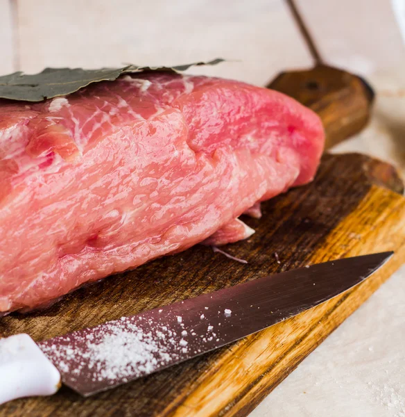 Сырое мясо на разделочной доске со специями, нож — стоковое фото