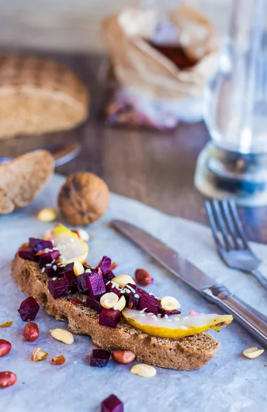 El bocadillo con hortalizas, las nueces y la pera sobre el pan de centeno —  Fotos de Stock