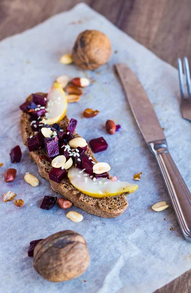 El bocadillo con hortalizas, las nueces y la pera sobre el pan de centeno —  Fotos de Stock