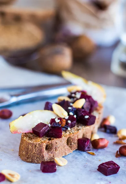 Sandwich with beets, walnuts and pear on black bread — Stock Photo, Image