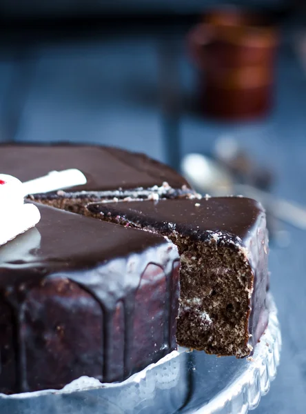 Cut a chocolate cake with butter cream and cherries, holiday — Stock Photo, Image