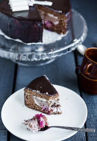 Eat with a spoon chocolate cake with butter cream and cherries — Stock Photo, Image