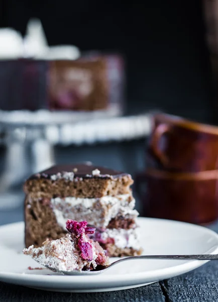 Äta med en sked choklad tårta med smörkräm och körsbär — Stockfoto