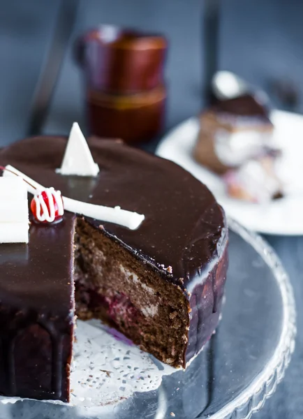 Sectie van chocolate cake met room en kers op de stand — Stockfoto