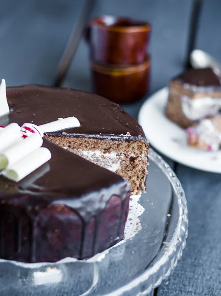 Avsnitt av chokladkaka med grädde och körsbär i montern — Stockfoto