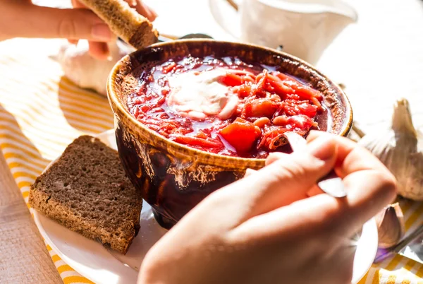 O processo de comer borscht vermelho com creme azedo, mão, cerâmica — Fotografia de Stock