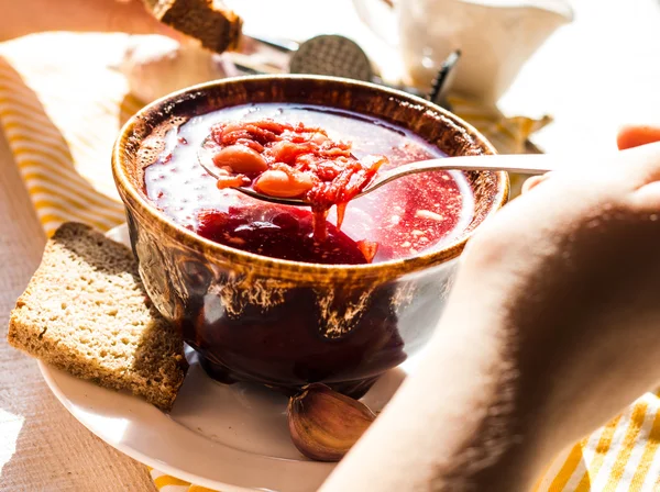 The process of eating red borscht with sour cream, hand, pottery — Stock Image The process of eating red borscht with sour cream, hand, pottery Stock Image