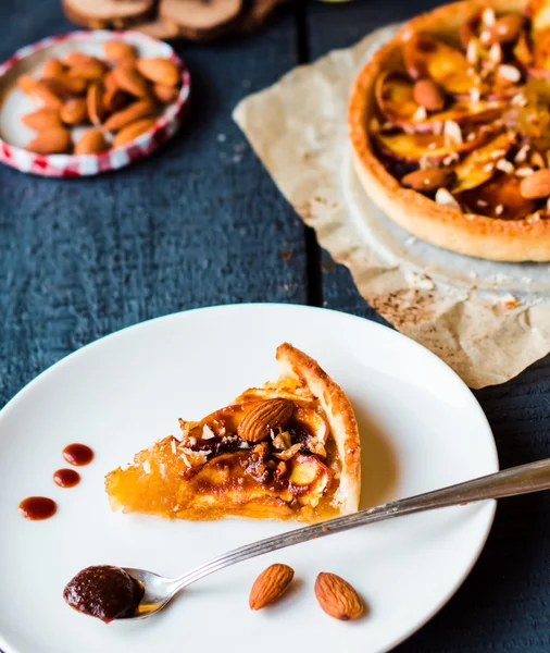 Stuk voor apple tart op een ronde plaat, lepel karamel — Stockfoto