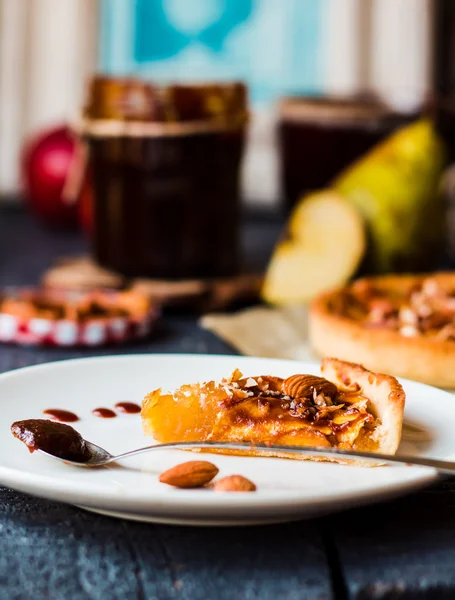 Piece of apple tart on a round plate, spoon caramel — Stock Photo, Image