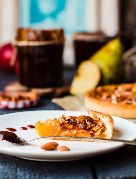 Кусочек яблочного пирога на круглой тарелке, ложка карамели — стоковое фото